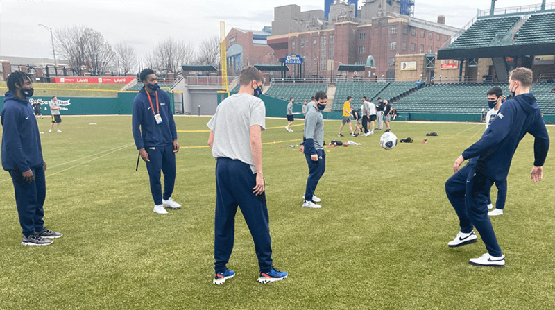 The men’s team enjoying a socially distant and NCAA-approved soccer intermezzo in a local ballpark in Indianapolis.