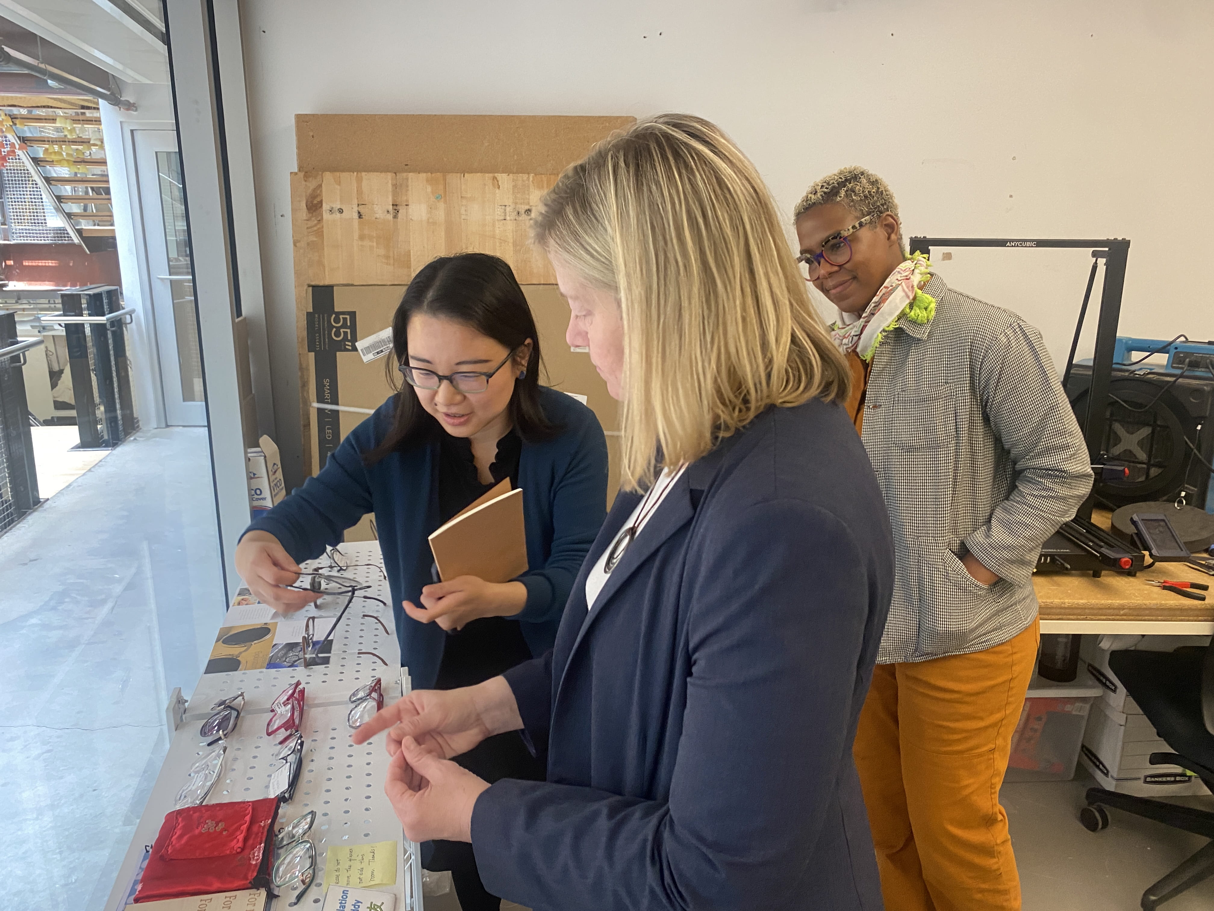 When Melissa Trego visited Drexel in April 2024, June He, left, showed her some product design students’ eyewear prototypes at the Empathic CoDesign Lab she leads. Raja Schaar, associate professor and associate program director for product design in the Westphal College of Media Arts & Design, looks on behind them. Photo credit: Khue Dao.