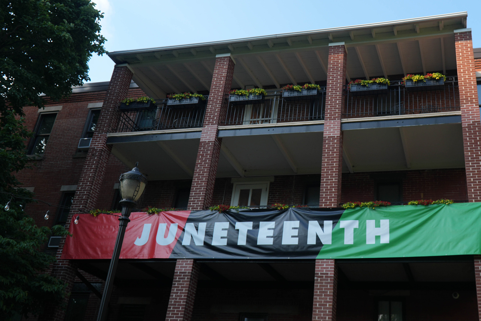 A Juneteenth banner hanging on the exterior of the Rush Building.