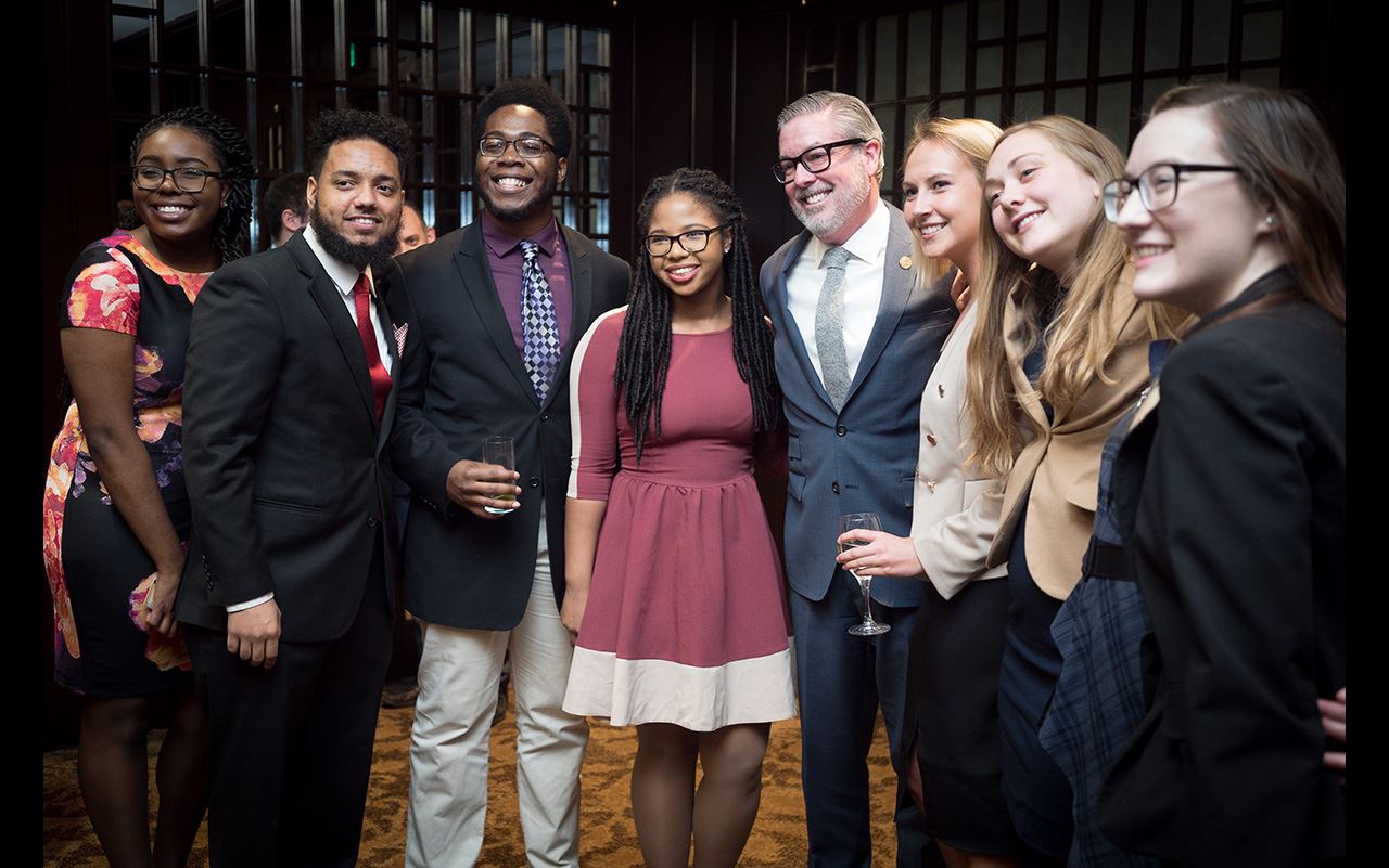 President John Fry posing with a group of engineering students at the Engineering Leader of the Year Award event and dinner honoring Chuck Pennoni.
