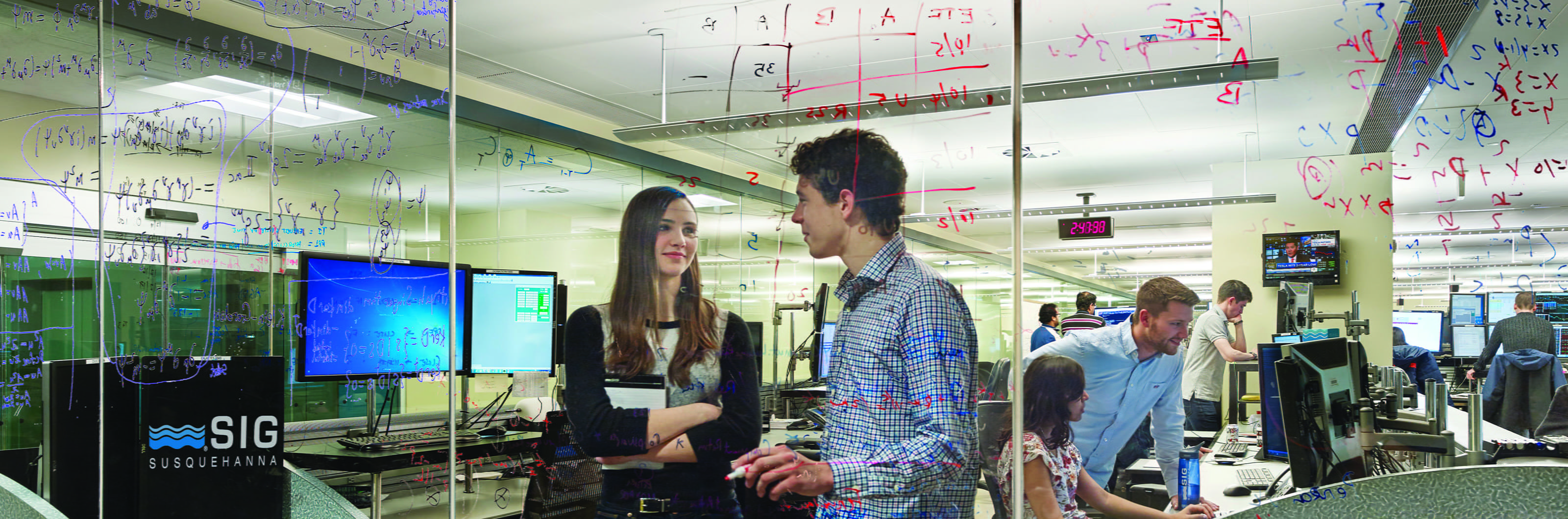 Two students converse in a computer lab