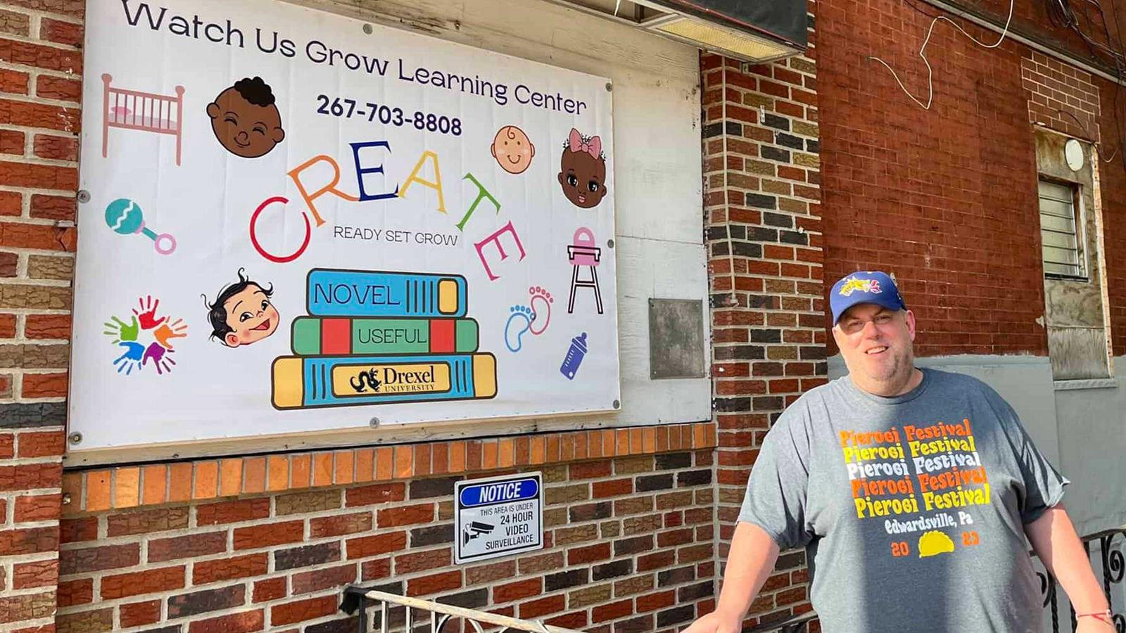 Drexel man in front of a daycare banner